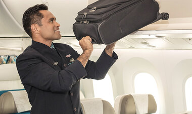 stewart portant un bagage cabine à bord d'air tahiti nui